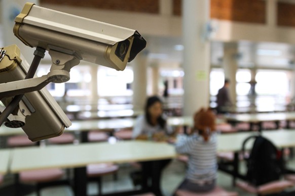 A security camera watches over a cafeteria in a school campus.