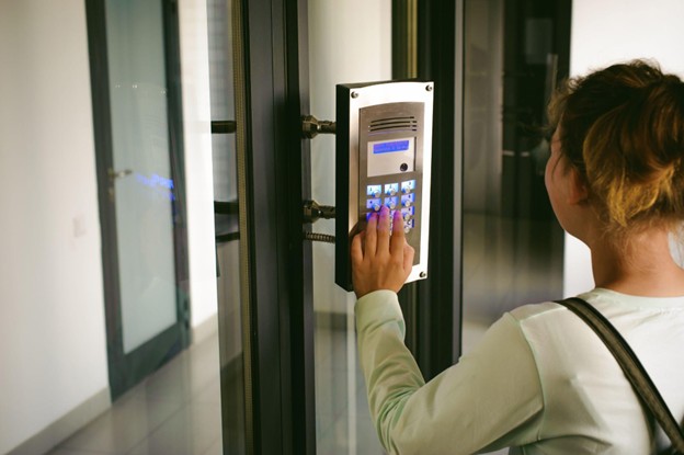 A user enters a secured area using an access control keypad linked to campus security systems.