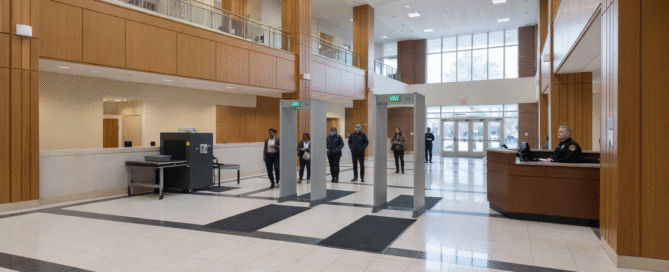 Two metal detectors being used to security the lobby of a building.