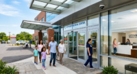 Family and hospital staff walking through a medical center entrance.