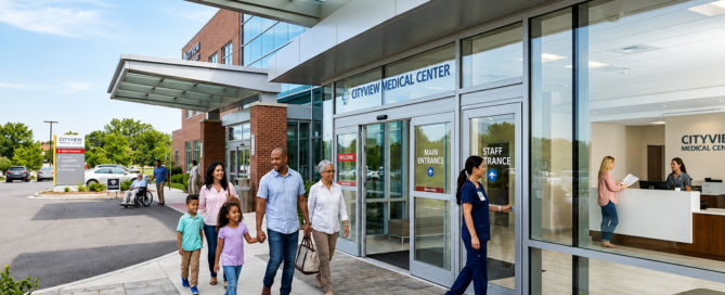 Family and hospital staff walking through a medical center entrance.